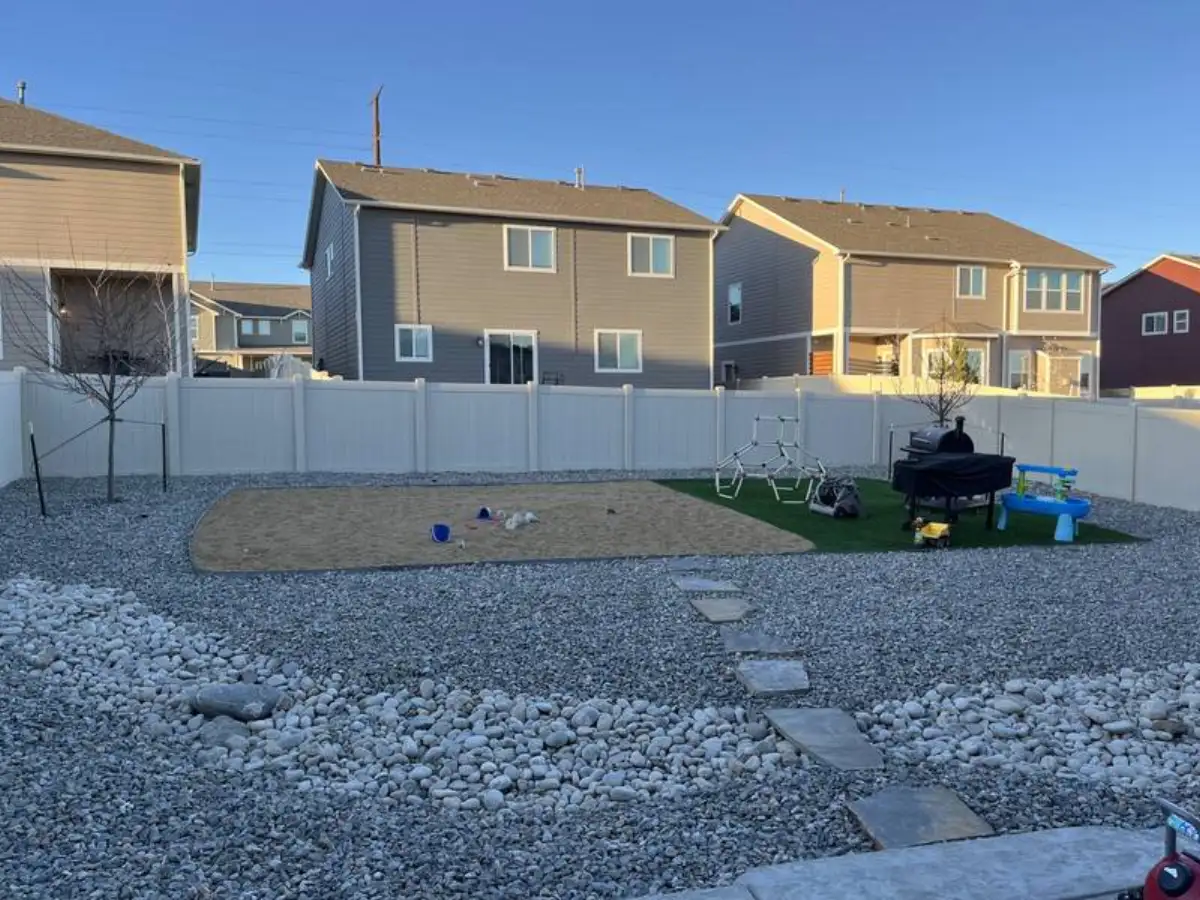 Backyard with artificial turf play area and decorative rock landscaping in Colorado Springs